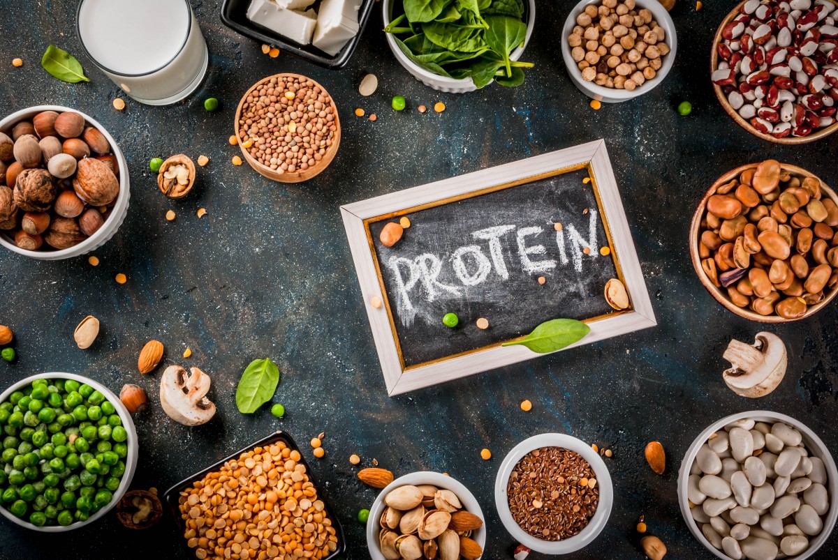 Nuts and legumes in bowls with protein sign