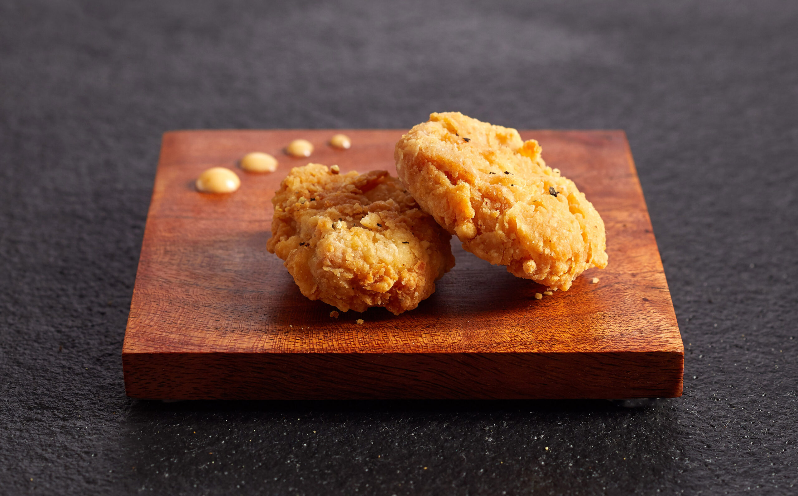 Historic, first-ever sale of cultivated meat is a huge step, but more investment is needed to bring it to the masses, says gfi executive 1 Two chicken bites on wood slate