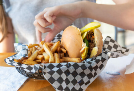 Plant-based burger with fries on checkered paper in a food service context
