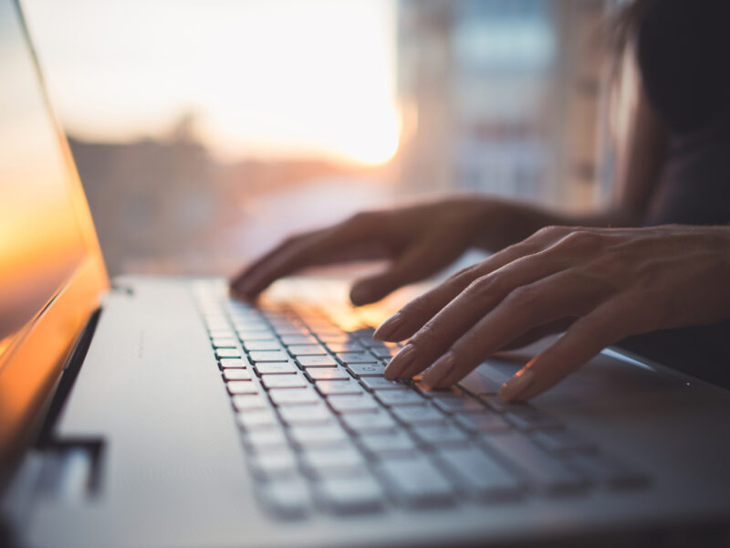 Hands typing on a laptop computer keyboard, representing mooc concept for cultured meat and plant-based meat science.