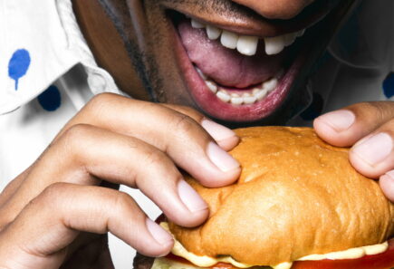 Person taking a bite of a burger