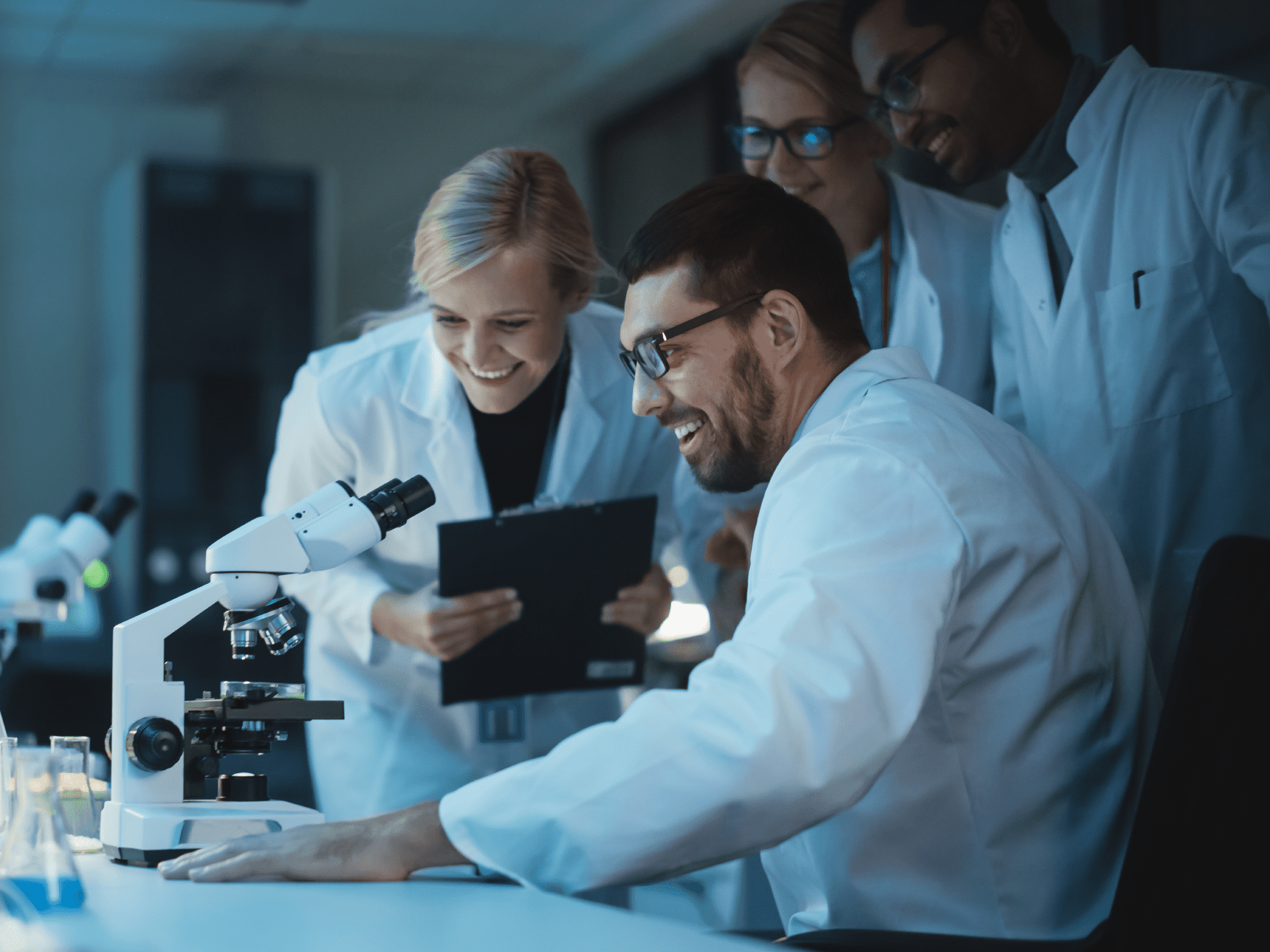 A team of scientists at a work station with a microscope