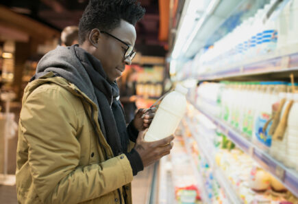 Person in a grocery store looking at plant-based milk