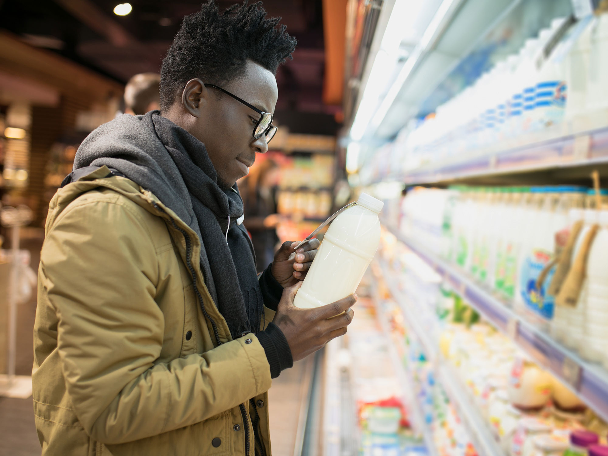 Person in a grocery store looking at plant-based milk