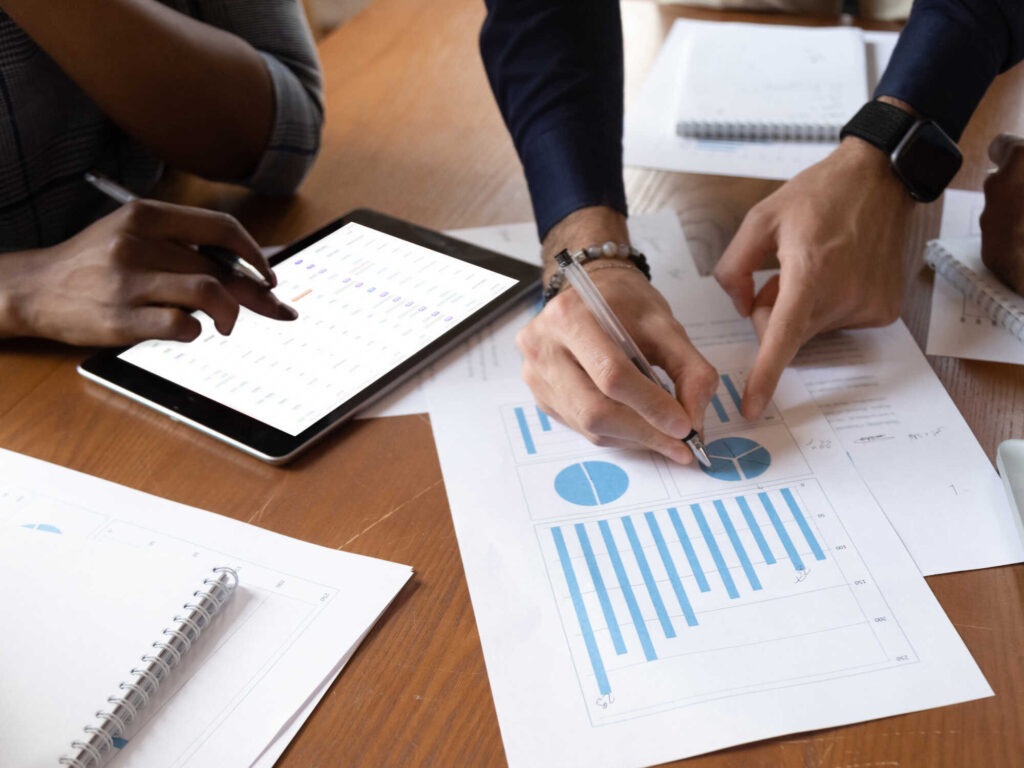 The top climate moments of this year and what they mean for alternative proteins 5 Two industry professionals work at a table while looking at a pie chart and tablet
