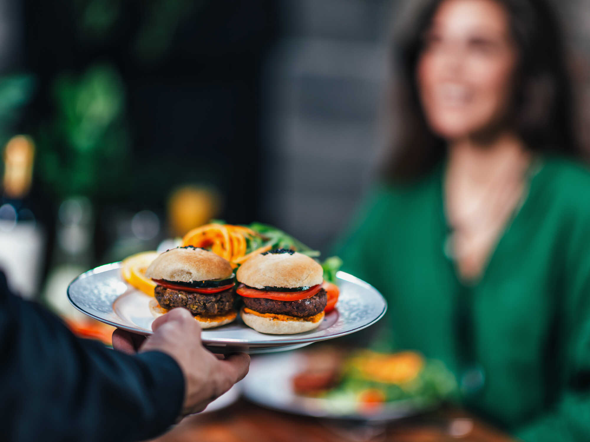 A close up view of two plant-based burger patties on a serving platter