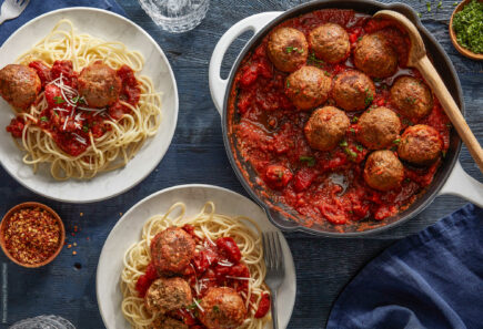 An overhead view of plates of spaghetti and meatballs
