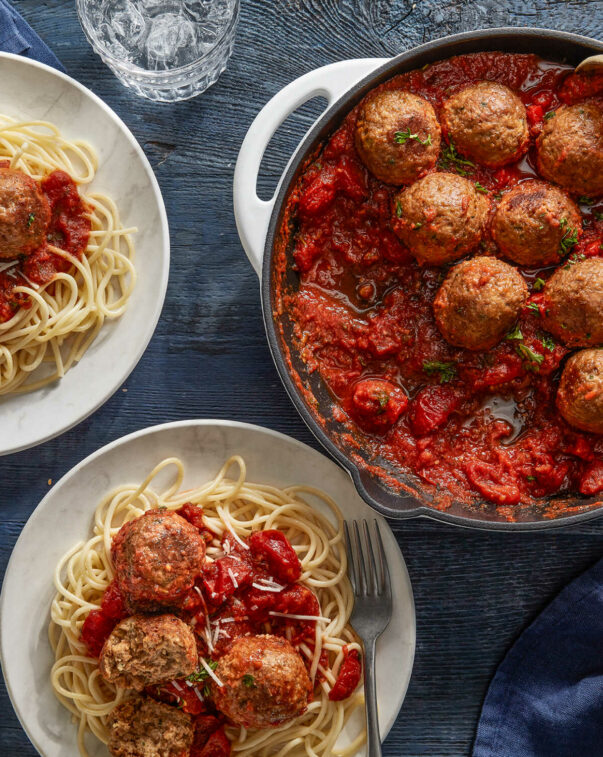 An overhead view of plates of spaghetti and meatballs
