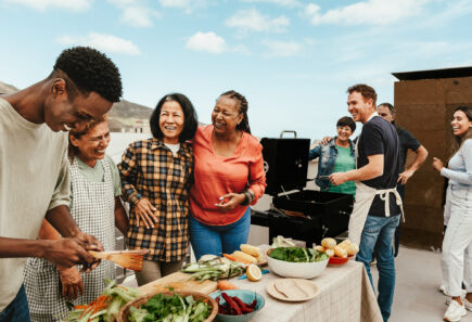 A group of people gather around a table with food